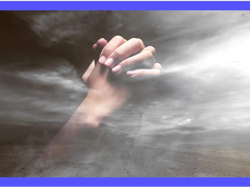 Immagine di una persona in preghiera con le mani giunte, rivolta verso il cielo, durante la cerimonia religiosa del 20 luglio 2022.