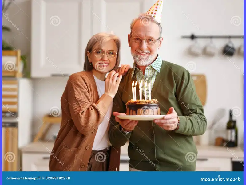 Una coppia di anziani si tiene per mano davanti a una torta di anniversario decorata con candele accese, sorridendo felici e riconoscenti mentre pregano insieme per celebrare il loro lungo cammino d'amore. Un momento di intimità e gratitudine che riflette la bellezza e la forza di un matrimonio duraturo.