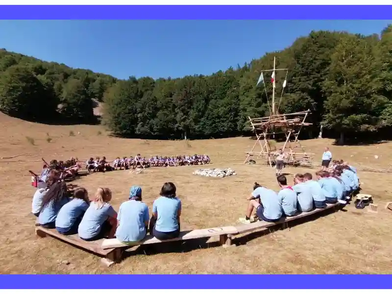 Un gruppo di giovani esploratori in uniforme scout circondati dalla natura mentre si riuniscono in preghiera, trascendendo la semplice esplorazione per connettersi spiritualmente con la bellezza e la forza dell'ambiente circostante. Le preghiere scout diventano così un'importante fonte d'ispirazione per questi giovani alla ricerca di significato e guida nella loro avventura di crescita e scoperta.